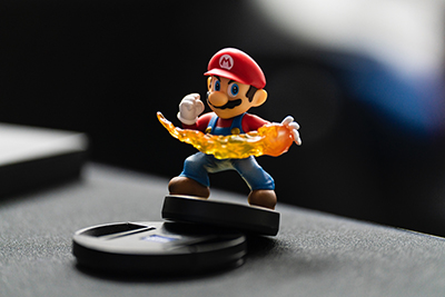 A photograph of the Mario Amiibo for Super Smash Bros. Mario has a fireball in his hand and is assuming a fighting stance.