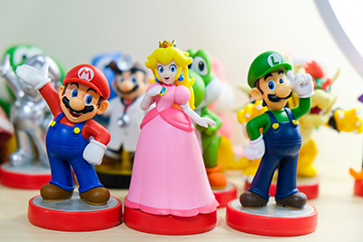 A photograph of all the Amiibos from the Mario Series that appear to be waving at the viewer.